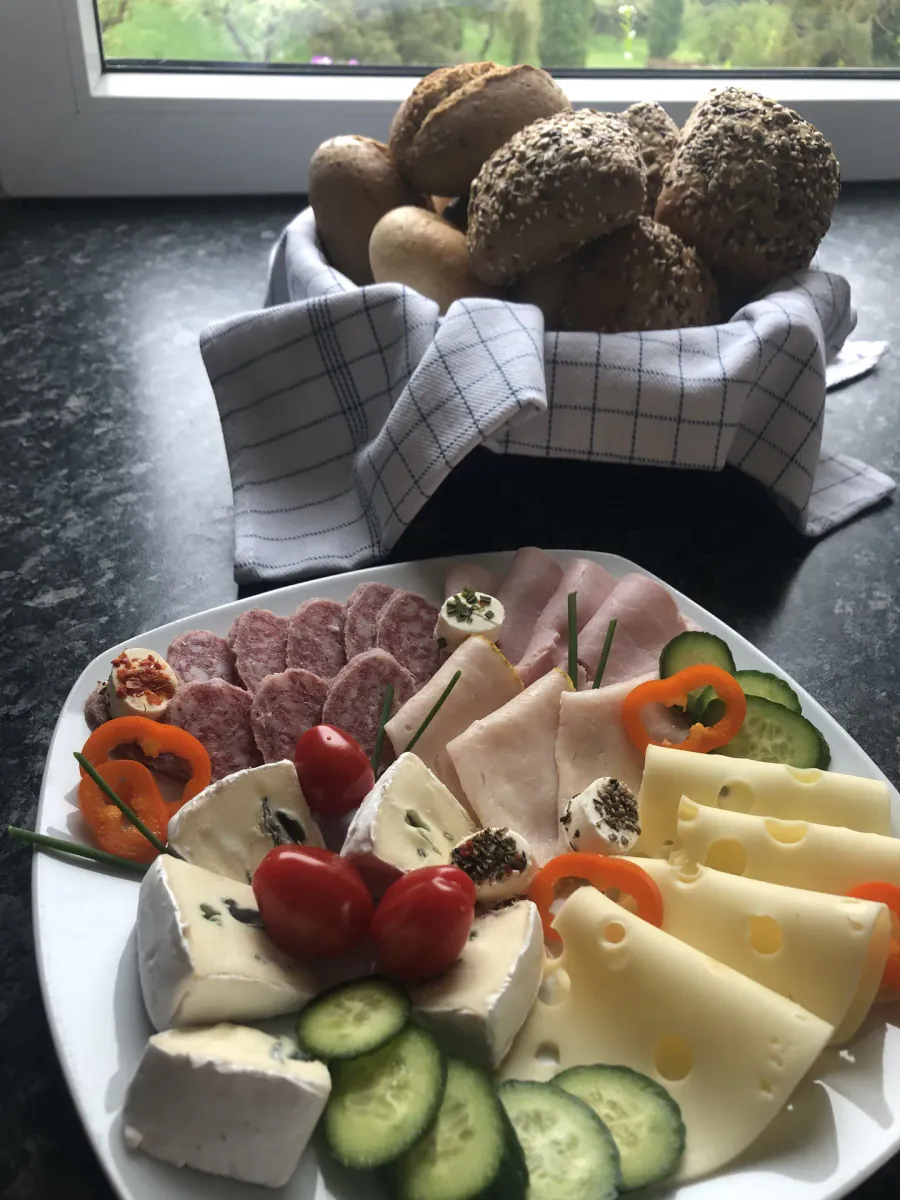 Hausgemachte Frühstücksplatte mit Marmelade, Käse und frischen Brötchen