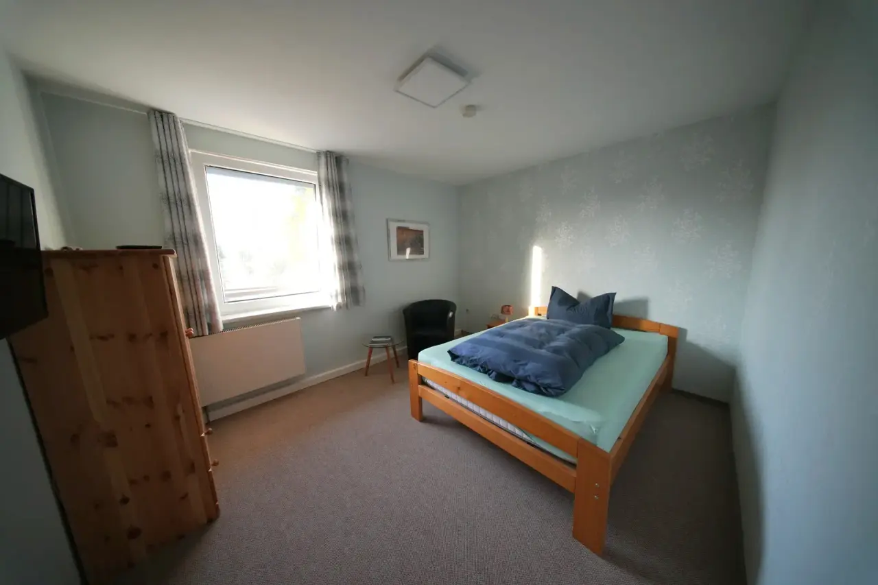 Einzelzimmer mit Einzelbett, Schrank und Fenster