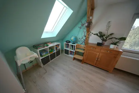 Schöne Aussicht – Kinderzimmer mit Spielecke, Hochstuhl und Spielzeugregalen
