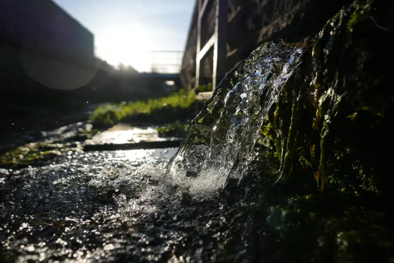 Wasser sprudelt aus einem Naturstein am eigenen Brunnen der Pension Volgenandt
