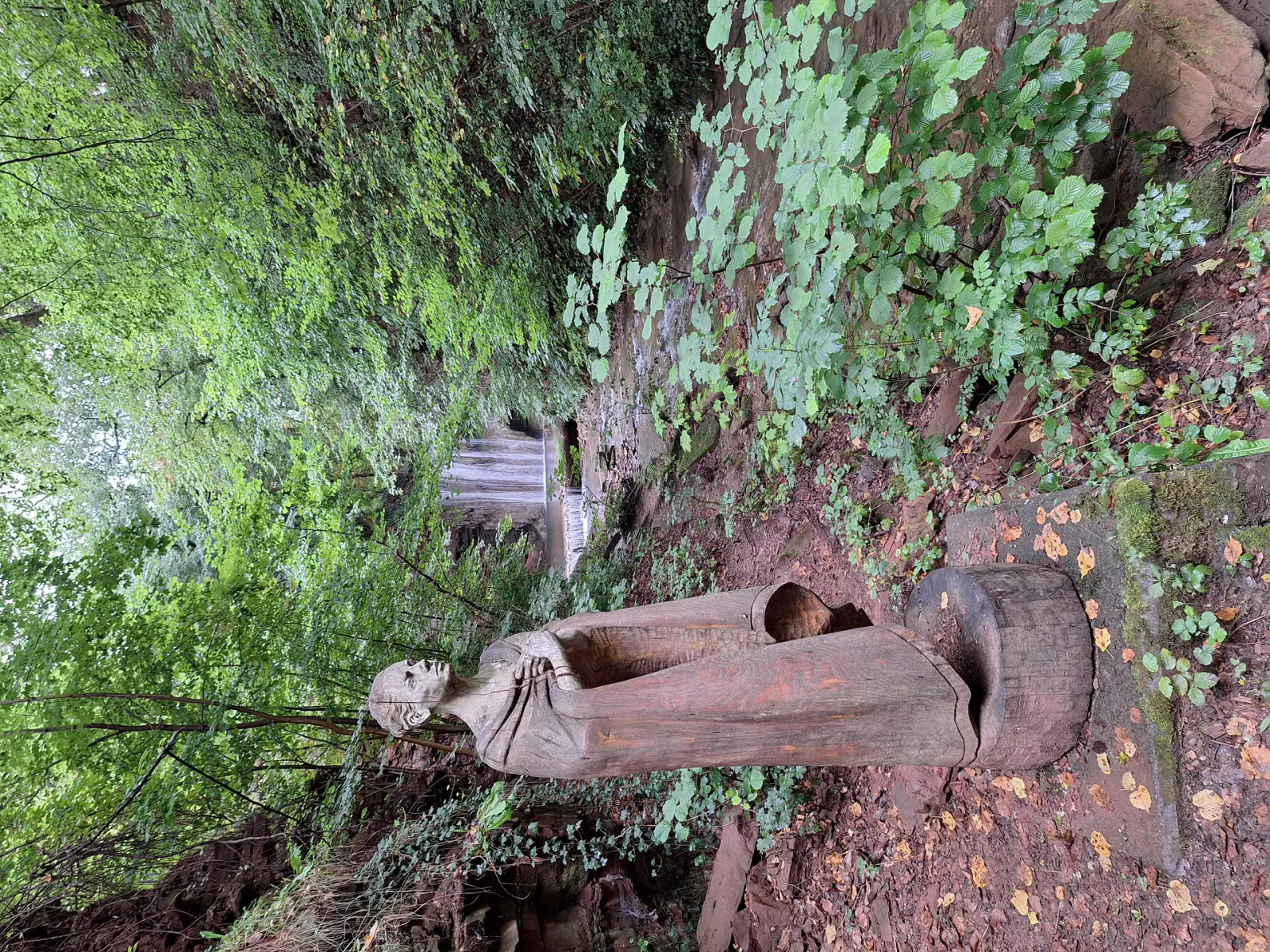 Wooden sculpture of the Rain Maiden at the Geislede waterfall in Heiligenstadt
