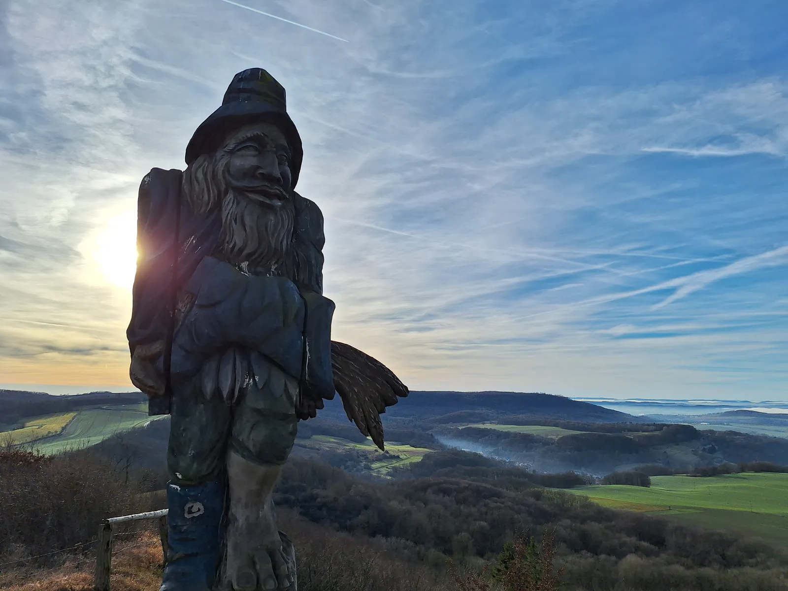 Wooden giant sculpture at Sonnenstein with sweeping panoramic view over the Eichsfeld in winter