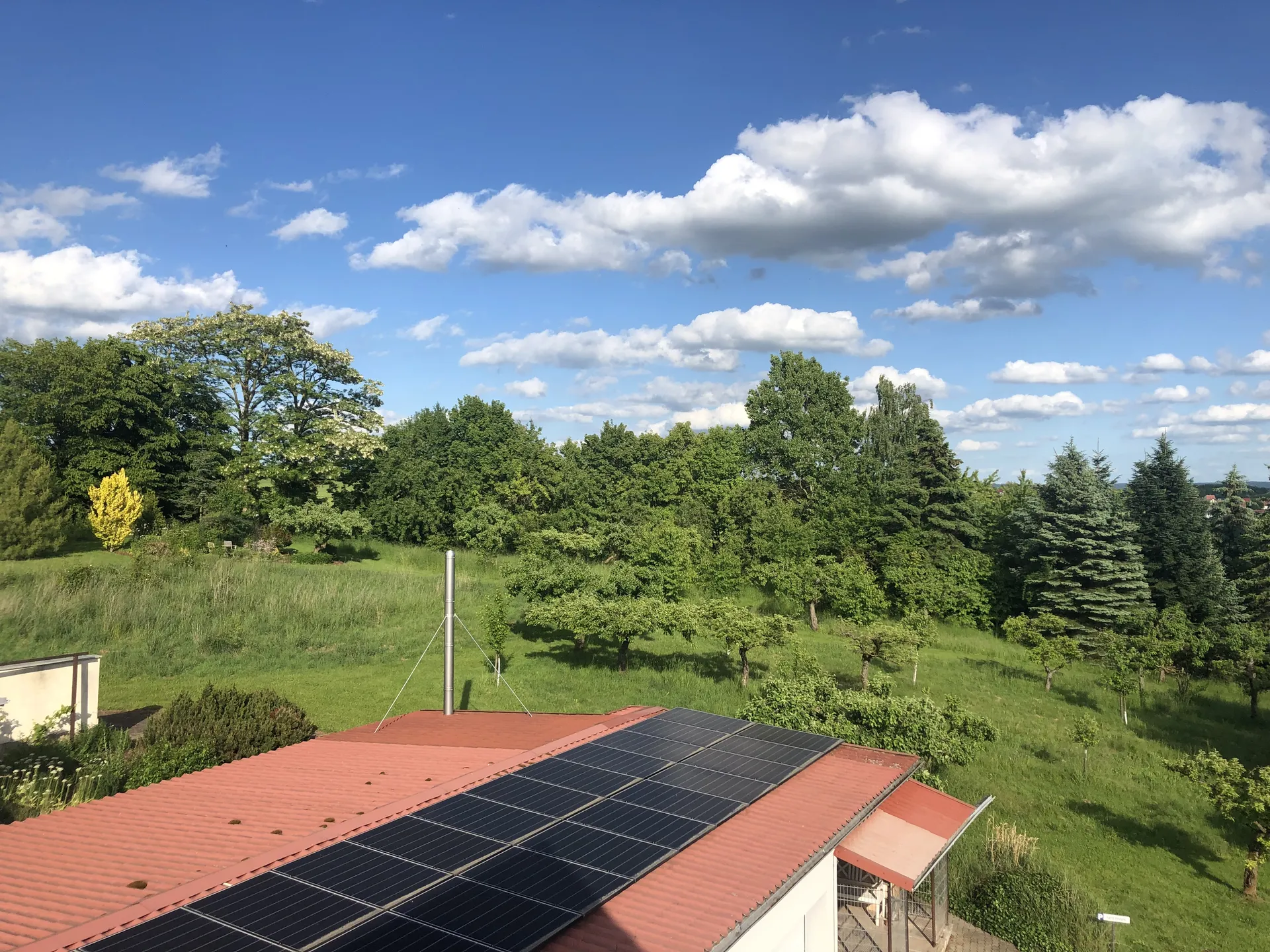 Photovoltaikanlage auf dem Dach der Pension mit grünem Garten