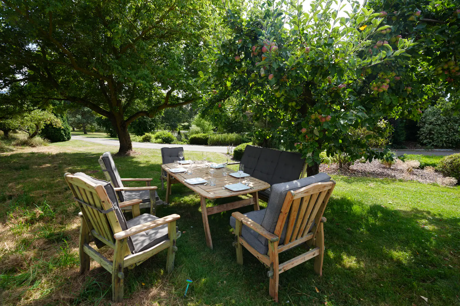 Gedeckter Tisch unter einem tragenden Apfelbaum im Garten der Pension Volgenandt