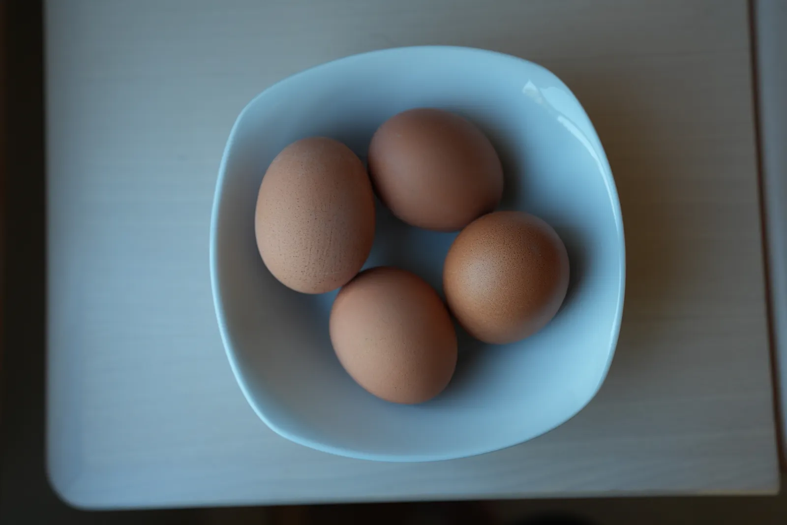 Vier frische braune Eier unserer Hühner in einer Schale