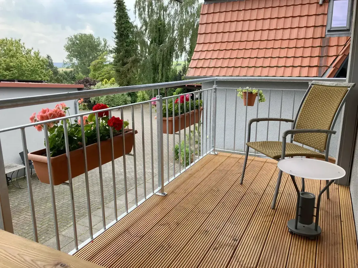 Balcony with wooden floor, flower boxes and roof view