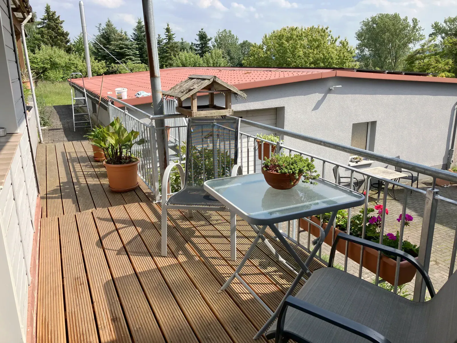 Balcony with birdhouse and garden panorama