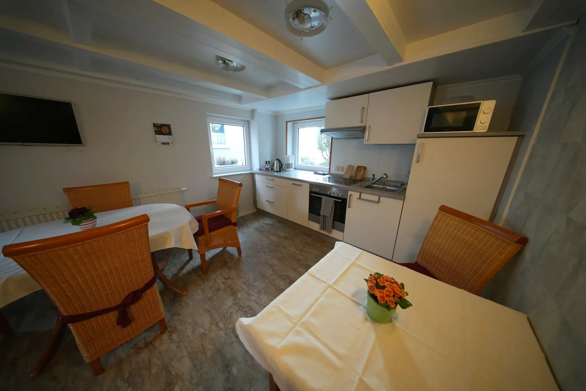 Shared kitchen with cooking area, dining space and fresh flowers